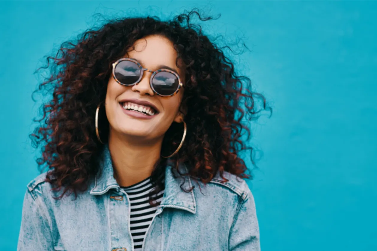 joyful woman of color with sunglasses